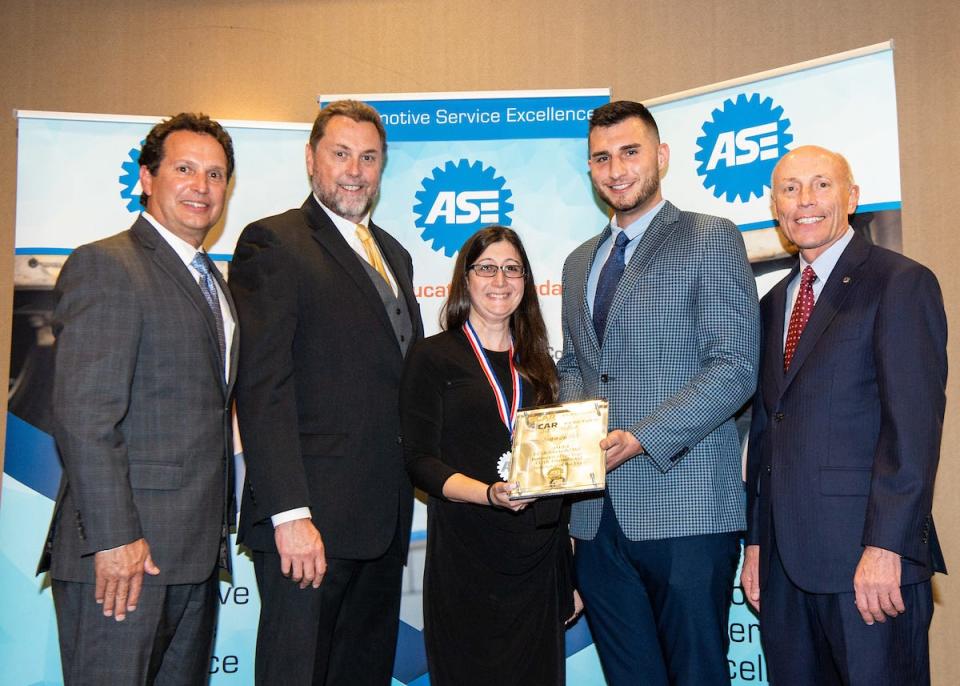 RVCC Automotive Technology Coordinator Sara Heller, center, is presented with the CCAR/Electude/ASE Instructor of the Year award by, from left,  Brad Pellman, chair of the ASE board of directors; Charlie Ayers, president of CCAR; Matt Bishop, business development manager, Electude; and Timothy Zilke, ASE president and ceo.