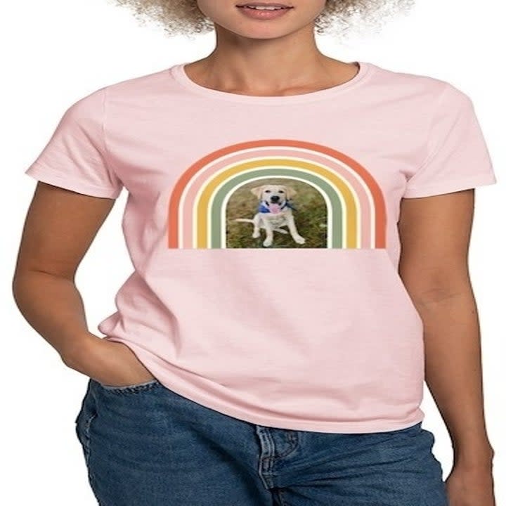 a model wearing a pink T-shirt with a photo of a dog under a rainbow graphic