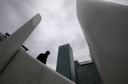 A man stands near the Canary Wharf business district, in east London