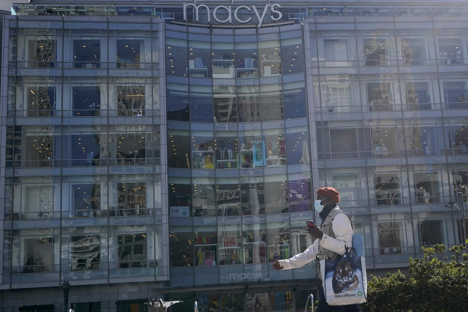 A pedestrian wears a protective face mask while walking at Union Square near a Macy's store during the coronavirus pandemic in San Francisco, Thursday, March 4, 2021. (AP Photo/Jeff Chiu)