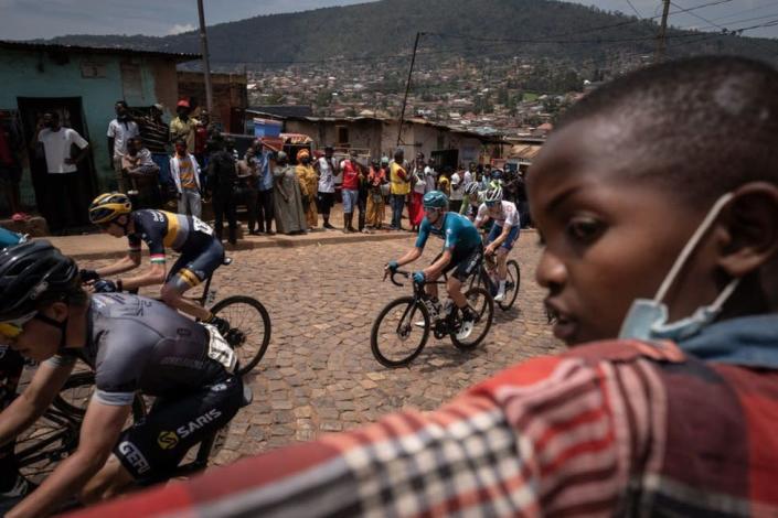 A child looks on as he watches cyclists competing during the final stage of the 14th Tour du Rwanda on 27 february 2022, in Kigali. - Eritrean Natnael Tesfatsion won the Tour of Rwanda for the second time, which ended on Sunday in the capital Kigali with the victory of Rwandan Mo&#xef;se Mugisha in the 7th stage.