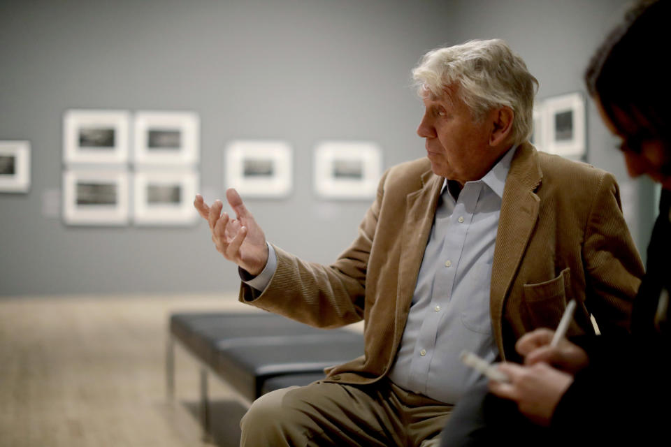 Veteran British conflict photographer Don McCullin speaks during an interview with The Associated Press at the launch of his retrospective exhibition at the Tate Britain gallery in London, Monday, Feb. 4, 2019. The exhibition includes over 250 of his black and white photographs, including conflict images from the Vietnam war, Northern Ireland, Cyprus, Lebanon and Biafra, alongside landscape and still life images. (AP Photo/Matt Dunham)