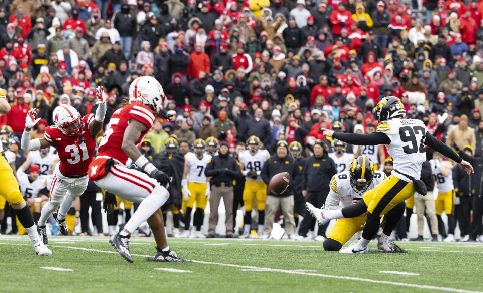 Iowa kicker Marshall Meeder (92) kicks a last-second field goal out of the hold by Tory Taylor (9) to win against Nebraska during an NCAA college football game Friday, Nov. 24, 2023, in Lincoln, Neb. (AP Photo/Rebecca S. Gratz)