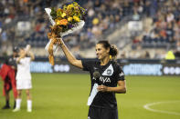 NJ/NY Gotham FC's Carli Lloyd holds up a bouquet after the team's NWSL soccer match against the Washington Spirits on Wednesday, Oct. 6, 2021, in Chester, Pa. (Charles Fox/The Philadelphia Inquirer via AP)