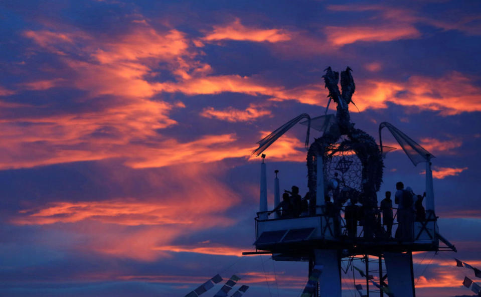 <p>Participants watch the sunset from the Tower of Ascension as approximately 70,000 people from all over the world gather for the 30th annual Burning Man arts and music festival in the Black Rock Desert of Nevada, Aug. 29, 2016. (REUTERS/Jim Urquhart)</p>