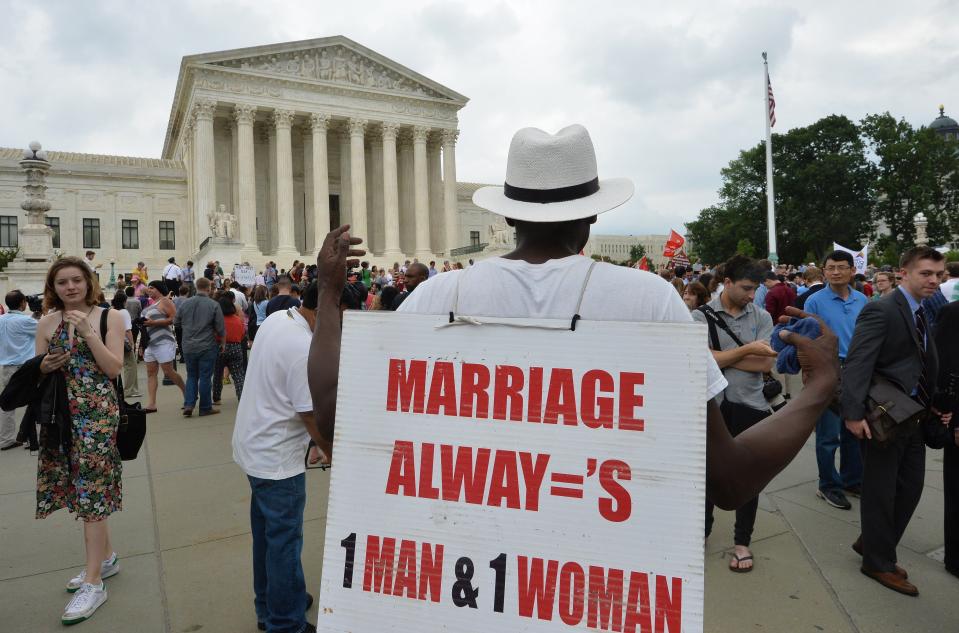 A man carries a protest poster outside the Supreme Court in Washington, DC on June 26. 2015 after its historic decision on gay marriage. The US Supreme Court ruled Friday that gay marriage is a nationwide right, a landmark decision in one of the most keenly awaited announcements in decades and sparking scenes of jubilation. The nation's highest court, in a narrow 5-4 decision, said the US Constitution requires all states to carry out and recognize marriage between people of the same sex.