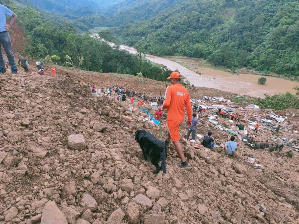 This photograph provided by India's National Disaster Response Force (NDRF) shows NDRF personnel and others trying to rescue those buried under the debris after a mudslide in Noney, northeastern Manipur state, India, Thursday, June 30, 2022. (National Disaster Reponse Force via AP)