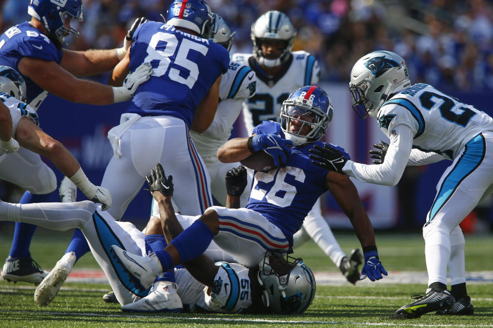 New York Giants' Saquon Barkley (26), center, is tackled during the second half an NFL football game Carolina Panthers, Sunday, Sept. 18, 2022, in East Rutherford, N.J. (AP Photo/John Munson)