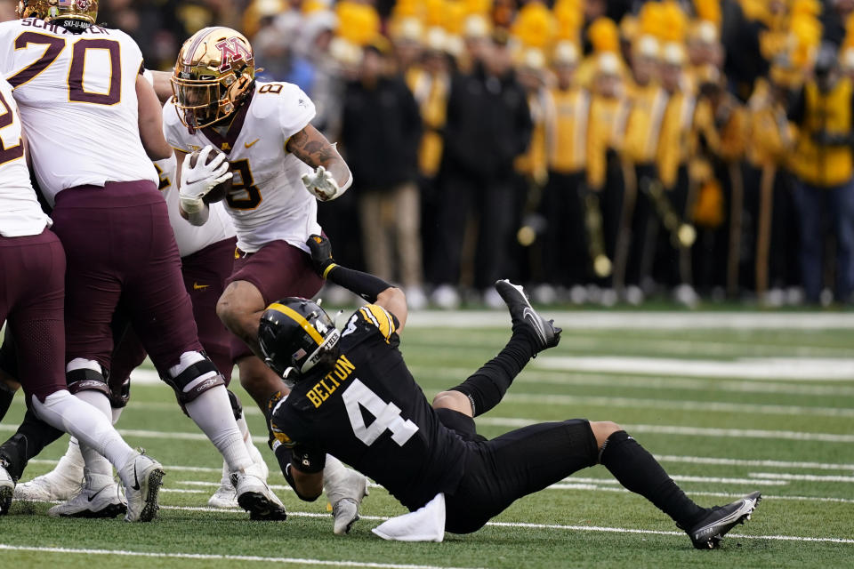 Minnesota running back Ky Thomas (8) tries to break a tackle by Iowa defensive back Dane Belton (4) during the first half of an NCAA college football game, Saturday, Nov. 13, 2021, in Iowa City, Iowa. (AP Photo/Charlie Neibergall)