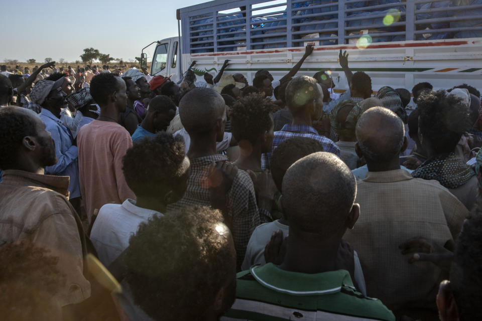 Tigray refugees who fled the conflict in Ethiopia's Tigray region, wait to receive aid at Umm Rakouba refugee camp in Qadarif, eastern Sudan, Tuesday, Nov. 24, 2020. (AP Photo/Nariman El-Mofty)