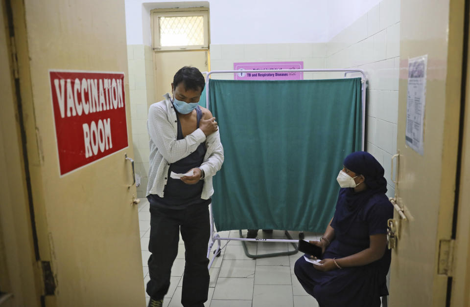 A man comes out after receiving COVID- 19 vaccine at a government hospital, in New Delhi, India, Monday, March 22, 2021. India has reported its highest number of coronavirus cases in four months, amid a worrying surge that has prompted multiple states to return to some form of restrictions on public gathering. (AP Photo/Manish Swarup)