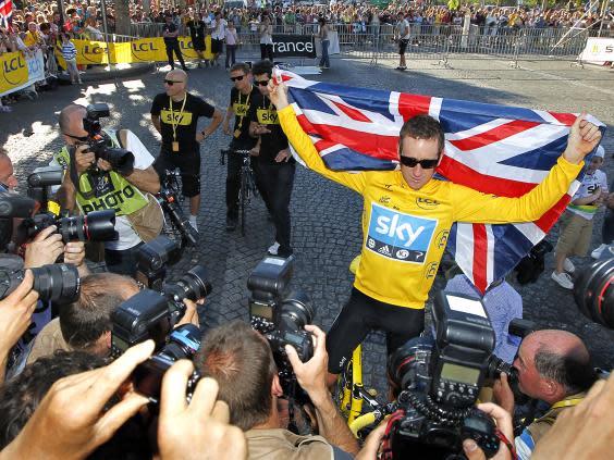 Wiggins surrounded by photographers celebrating his Tour de France victory on the Champs Elysees in 2012 (REUTERS)