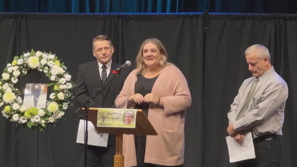 Tristan's mom Paule (centre) and dad Jason (right) speak at the Saturday memorial service. 