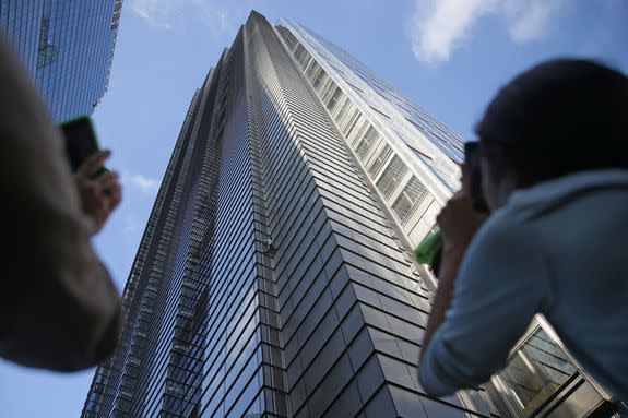 People watch Robert climbing Heron Tower, 110 Bishopsgate, in central London.