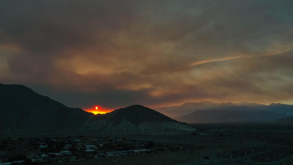 The sun sets over the San Jacinto Cove in Palm Springs,  Calif., as the Highland Fire in Beaumont burns about 20 miles to the west.  Air quality throughout the Coachella Valley was poor the evening of July 14, 2023. 