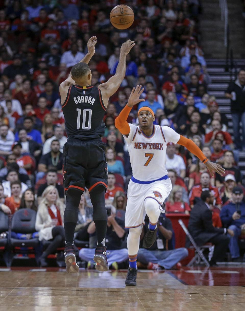 Houston Rockets guard Eric Gordon (10) shoots over New York Knicks forward Carmelo Anthony (7) during the first half of an NBA basketball game Saturday, Dec. 31, 2016, in Houston. (AP Photo/Bob Levey)