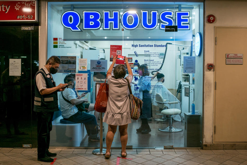 SINGAPORE - 2020/05/13: A man stands outside a hair salon while wearing a face mask as a preventive measure during the Coronavirus (COVID-19) crisis. Singapore has so far confirmed 26,773 coronavirus cases, 21 deaths and 4,809 recovered. (Photo by Maverick Asio/SOPA Images/LightRocket via Getty Images)