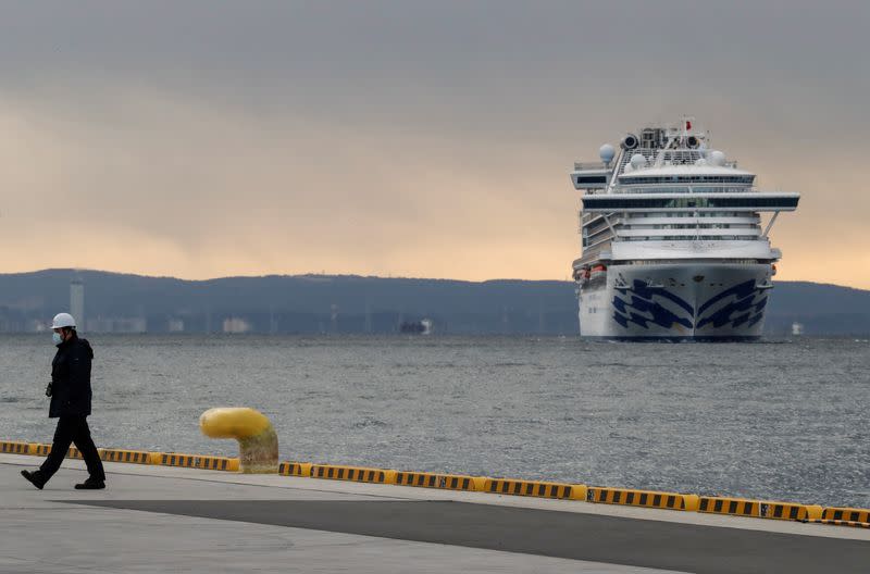 Foto del jueves de un trabajador con una máscara en el puerto de Yokohama cerca de un crucero en el que 10 pasajeros dieron positivo de coronavirus