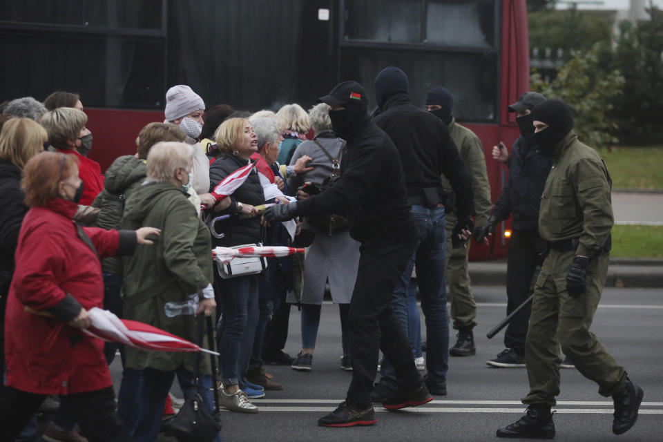 People, most of them elderly women, argue with plainclothes policemen during an opposition rally to protest the official presidential election results in Minsk, Belarus, Monday, Oct. 12, 2020. Riot police clashed with protesting pensioners in central Minsk on Monday. The pensioners marched in a column through central Minsk, carrying flowers and posters with slogans such as "The grandmas are with you (protesters)." (AP Photo)