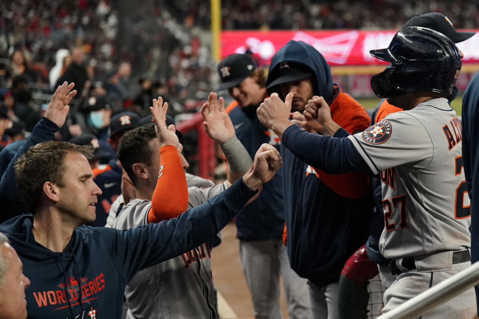 Houston Astros' Jose Altuve celebrates in the dugout after scoring on a single by Carlos Correa during the eighth inning in Game 5 of baseball's World Series between the Houston Astros and the Atlanta Braves Sunday, Oct. 31, 2021, in Atlanta. (AP Photo/David J. Phillip)