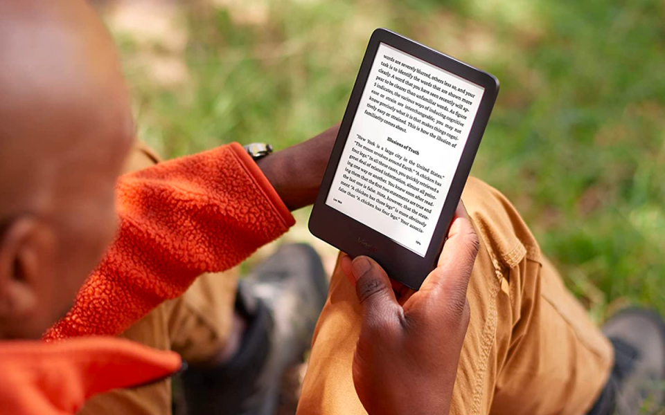 a man reading in the park with his Amazon 2022 kindle