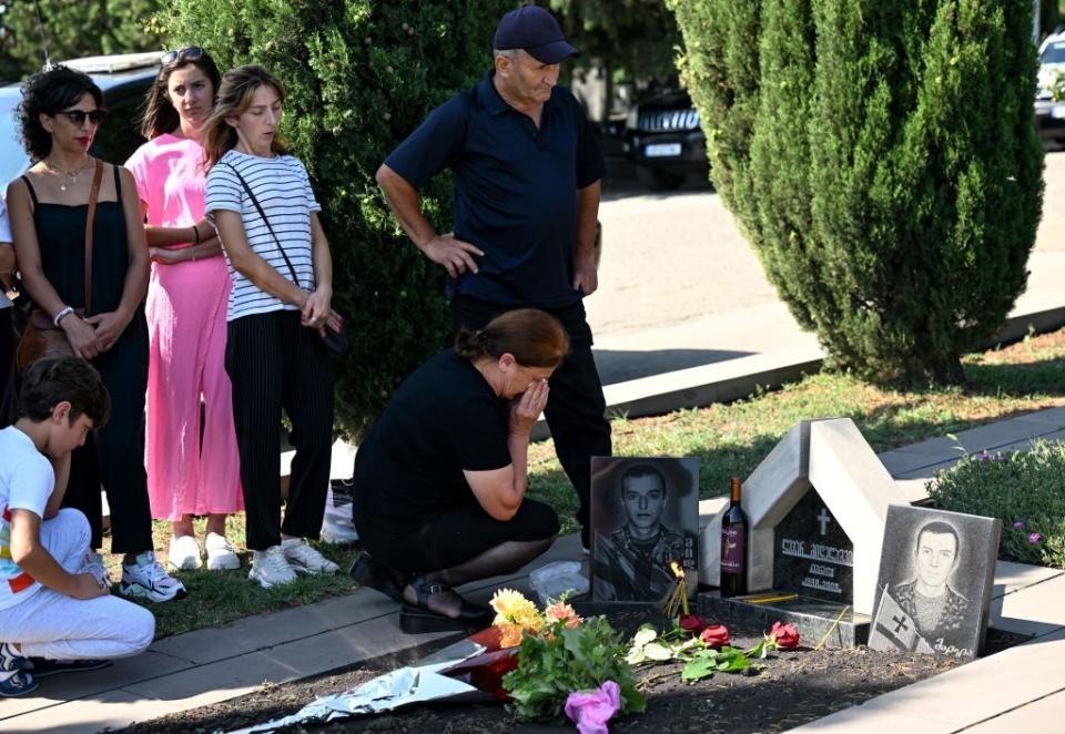 Relatives of Georgian servicemen killed during the 2008 Russo-Georgian War visit their graves during a ceremony marking the 15th anniversary of the war, at the memorial cemetery in Tbilisi, Georgia, on Aug. 8, 2023. (Photo by VANO SHLAMOV/AFP via Getty Images)