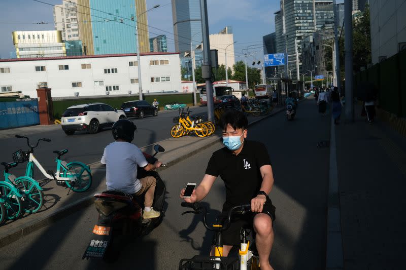 Man wearing a face mask rides a bicycle of the bike sharing service by Meituan, following the coronavirus disease (COVID-19) outbreak, in Beijing's central business area