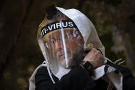 An Ultra-Orthodox Jewish man wears a face mask during a morning prayer next to his house as synagogues are limited to twenty people during a nationwide three-week lockdown to curb the spread of the coronavirus, in Bnei Brak, Israel, Thursday, Sept 24, 2020. Israel moved to further tighten its second countrywide lockdown as coronavirus cases continued to soar. The Cabinet voted to close all nonessential businesses, including open-air markets. Prayers and political demonstrations would be limited to open spaces and no more than 20 people, and participants would not be able to travel more than a kilometer (0.6 miles) from home for either. (AP Photo/Oded Balilty)