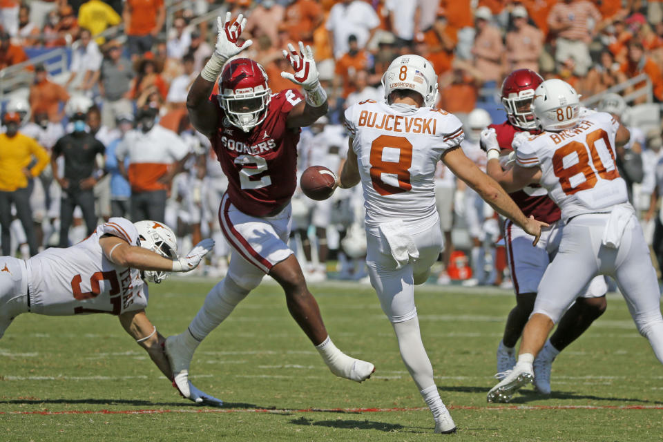 Oklahoma linebacker David Ugwoegbu (2) blocks a punt by Texas punter Ryan Bujcevski (8) during an NCAA college football game in Dallas, Saturday, Oct. 10, 2020. (AP Photo/Michael Ainsworth)