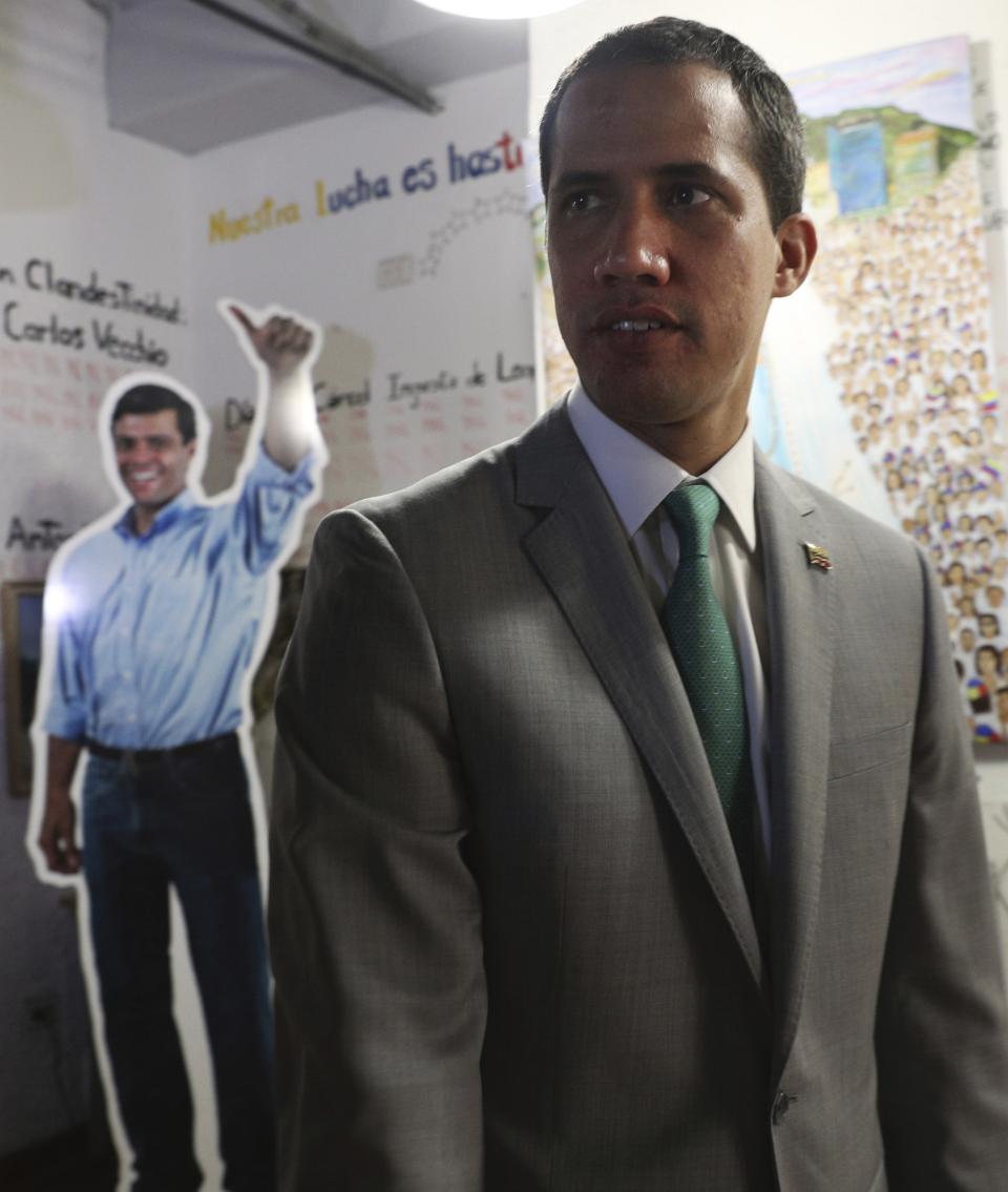 Venezuela's opposition leader Juan Guaidó, who declared himself the interim-president of Venezuela, stands near a life size cutout of the founder of the Popular Will party Leopoldo Lopez, at party headquarters in Caracas, Venezuela, Friday, May 10, 2019. The 35-year-old national assembly president, who the U.S. and 50 other countries recognize as Venezuela's rightful leader, sat for an interview with The Associated Press on Friday. (AP Photo/Martin Mejia)