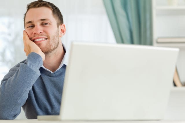 CF8RG4 Businessman smiling tired in his homeoffice Businessman; smiling; tired; homeoffice; Young; Adult; Man; Male; Caucasian;