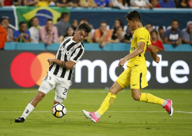 Paulo Dybala (L) of Juventus fights for the ball with Yuri Berchiche of PSG during their International Champions Cup match, at Hard Rock Stadium in Miami, Florida, on July 25, 2017