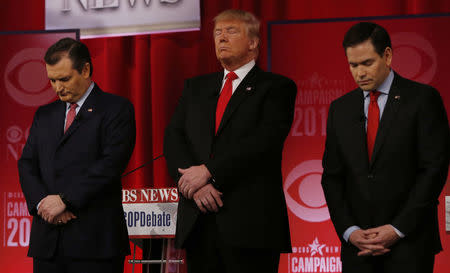 Republican U.S. presidential candidates (L-R) Senator Ted Cruz, businessman Donald Trump and Senator Marco Rubio pause for a moment of silence in honor of deceased Supreme Court Associate Justice Antonin Scalia before the start of the Republican U.S. presidential candidates debate sponsored by CBS News and the Republican National Committee in Greenville, South Carolina February 13, 2016. REUTERS/Jonathan Ernst