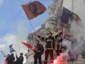 Firemen wave flags atop a statue as they protest with hospital staff on wages, working conditions and pensions, Tuesday, Oct. 15, 2019 in Paris. (AP Photo/Michel Euler)