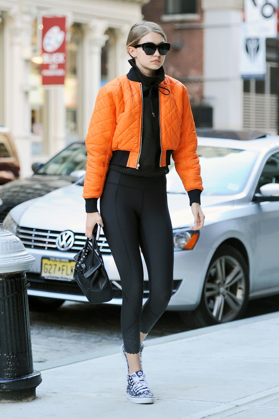 <p>Out in NYC wearing an orange bomber jacket with black leggings and printed sneakers. </p>
