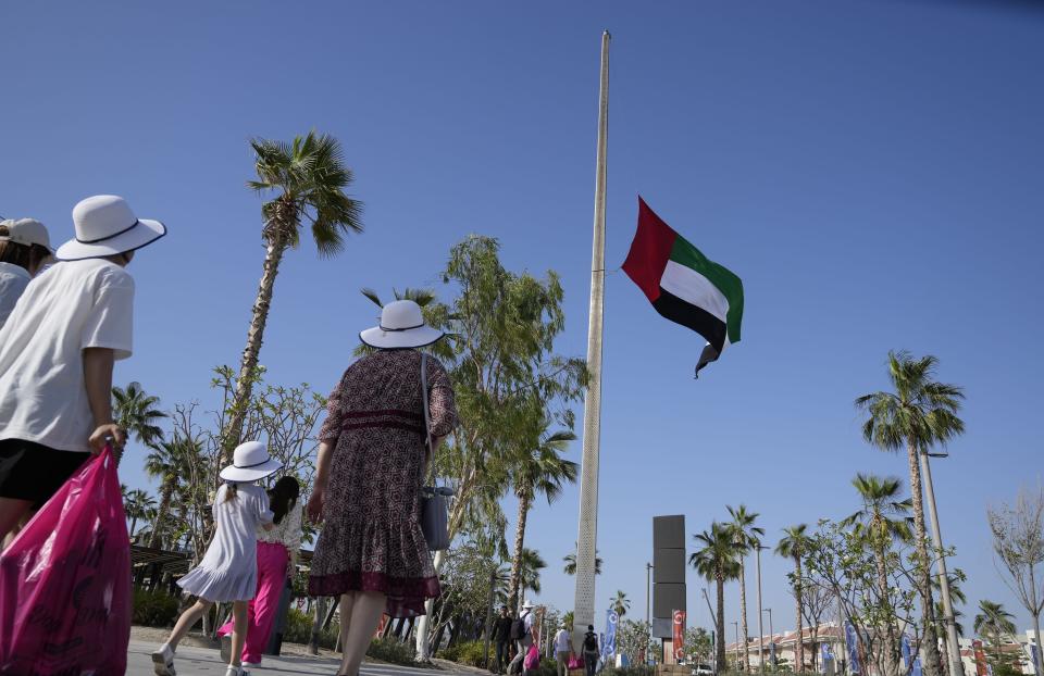 People pass by the UAE national flag flies at half-staff after the announcement of the Emirates president's death, in Dubai, United Arab Emirates, Friday, May 13, 2022. Sheikh Khalifa died Friday, May 13, 2022, the government's state-run news agency announced in a brief statement. He was 73. (AP Photo/Kamran Jebreili)