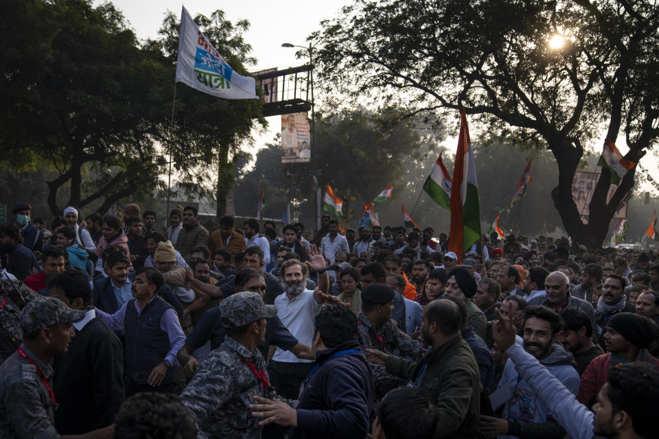 Rahul Gandhi, leader of India's opposition Congress party, centre in white T-shirt, waves to his supporters during a march, in New Delhi, India, Saturday, Dec. 24, 2022. Rahul Gandhi, leader of India's beleaguered opposition Congress party, on Saturday marched in New Delhi along with his supporters, part of his five-month-long 3,570km (2,218-mile) countrywide trek through 12 states that began 105 days ago.(AP Photo/Altaf Qadri)