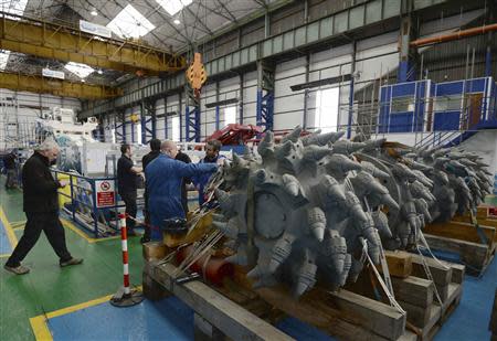 Employees stand near components of a subsea mining machine being assembled by Soil Machine Dynamics (SMD) for Nautilus Minerals at Wallsend, northern England April 14, 2014. REUTERS/ Nigel Roddis