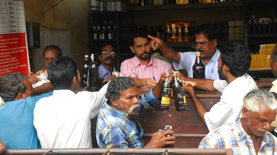 Customers buying liquor from a shop in Kerala, India