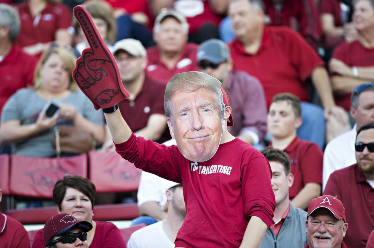 <span class="caption">The lines between political fandom and sports fandom have blurred.</span> <span class="attribution"><a class="link " href="https://www.gettyimages.com/detail/news-photo/fan-of-the-arkansas-razorbacks-with-his-donald-trump-face-news-photo/615582270?adppopup=true" rel="nofollow noopener" target="_blank" data-ylk="slk:Wesley Hitt/Getty Images;elm:context_link;itc:0;sec:content-canvas">Wesley Hitt/Getty Images</a></span>