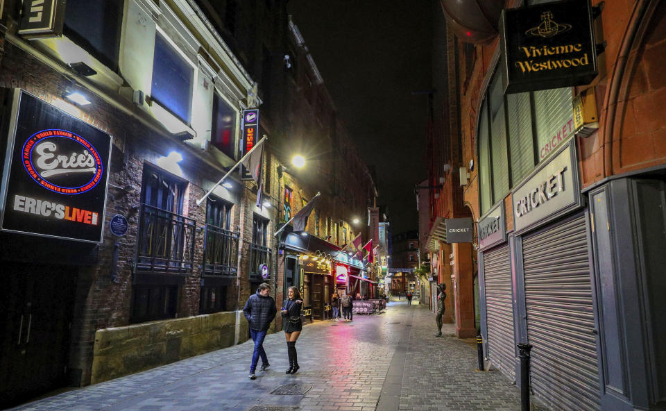 An empty looking Mathew Street in Liverpool, England, as drinkers stay at home and follow coronavirus restrictions, Friday, Oct. 9, 2020, ahead of a new three-tiered system of restrictions that Prime Minister Boris Johnson will outline on Monday that is expected to cause pubs and restaurants to shut across the north of England. (Peter Byrne/PA via AP)