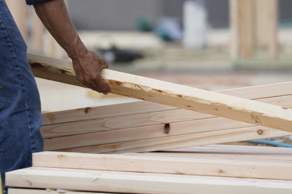 A workman arranges a beam on a frame at a new housing site in Madison County, Miss., Tuesday, March 16, 2021. Rising prices for a variety of commodities are contributing to a jump in prices at the consumer level, with Americans paying more for meat, gasoline, items they keep in their homes and even the homes themselves.(AP Photo/Rogelio V. Solis)