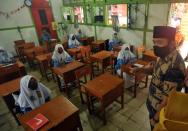 Students wear protective masks are pictured during learning activity at a school amid COVID-19 pandemic in Padangpanjang