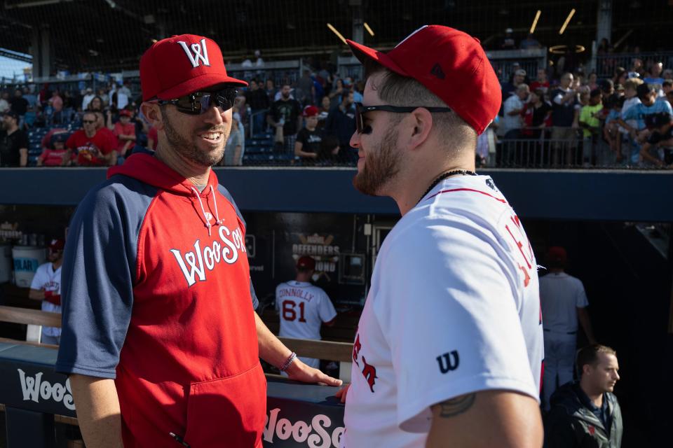 WooSox manager Chad Tracy, left, talks to catcher Caleb Hamilton during a game in September.