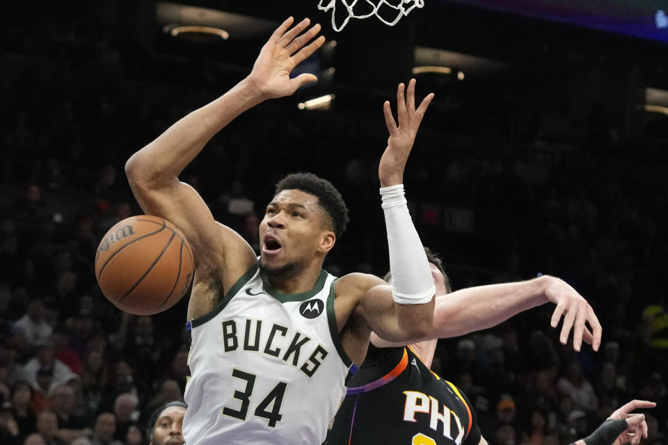 Milwaukee Bucks forward Giannis Antetokounmpo (34) is fouled by Phoenix Suns center Jusuf Nurkic, right, during the first half of an NBA basketball game Tuesday, Feb. 6, 2024, in Phoenix. (AP Photo/Ross D. Franklin)