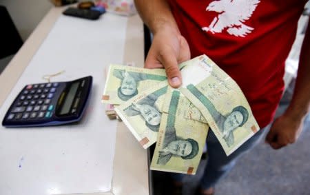 FILE PHOTO: A vendor inspects Iranian rials at a currency exchange shop in Baghdad, Iraq, August 8, 2018. REUTERS/Khalid Al-Mousily/File Photo