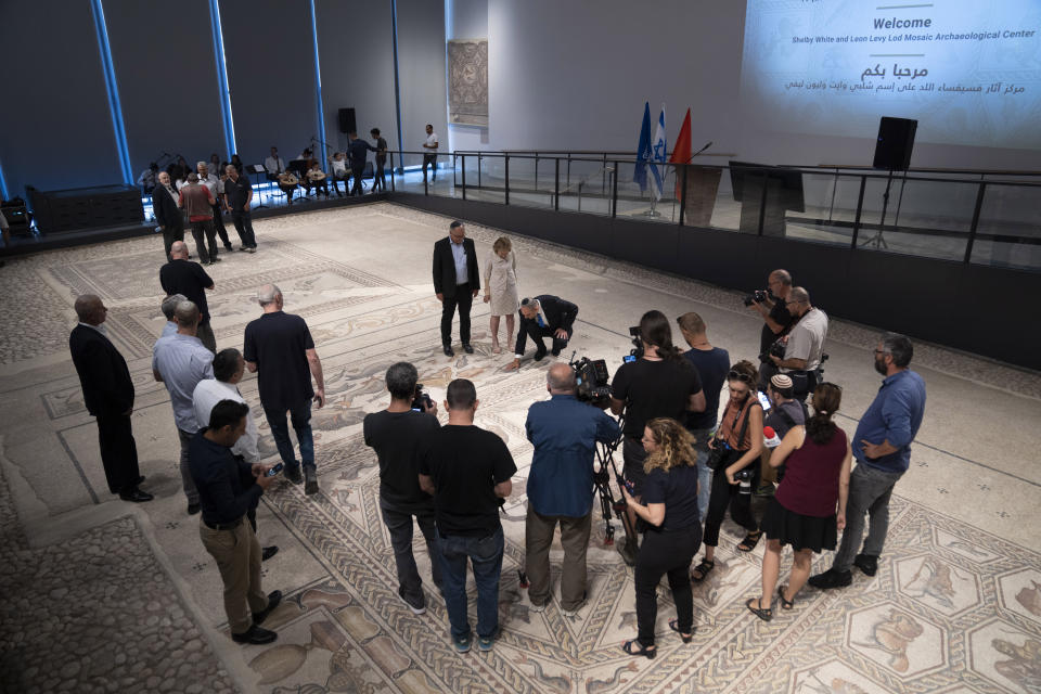 Shelby White, center, Lod mayor Yair Revivo, and Israel Antiquities Authority Director Eli Eskosido, look at a restored Roman-era mosaic during the inauguration of the Shelby White & Leon Levy Lod Mosaic Archaeological Center, in Lod, central Israel, Monday, June 27, 2022. A series of well-preserved ancient Roman mosaics have returned home to the central Israel city of Lod after more than a decade touring the world's most prominent museums. Israel on Monday inaugurated a new museum to house the artworks that once adorned a Roman-era villa. Shelby is one of the donors of the museum. (AP Photo/Oded Balilty)