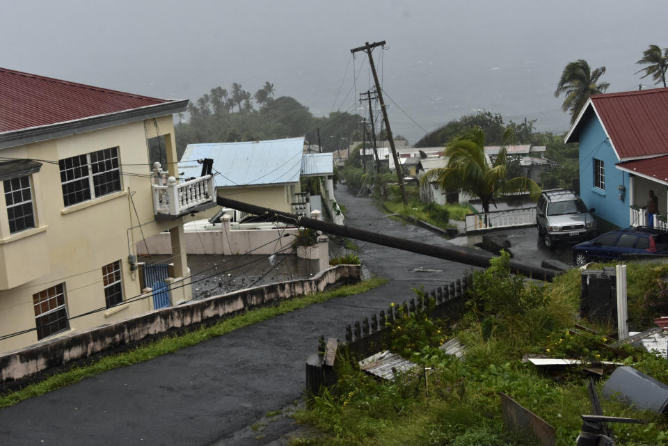 An electrical pole felled by Hurricane Elsa leans on the edge of a residential balcony, in Cedars, St. Vincent, Friday, July 2, 2021. Elsa strengthened into the first hurricane of the Atlantic season on Friday as it blew off roofs and snapped trees in the eastern Caribbean, where officials closed schools, businesses and airports. (AP Photo/Orvil Samuel)