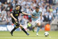 Wigan Athletic's Antolin Alcaraz (left) and Manchester City's Carlos Tevez (right) battle for the ball