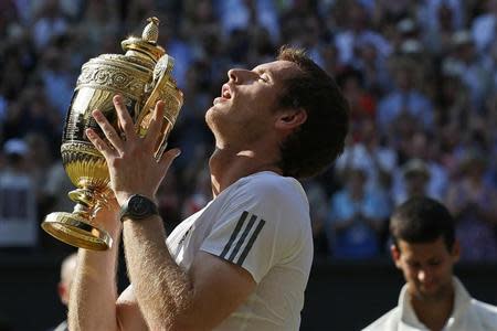 Andy Murray of Britain holds the winners trophy after defeating Novak Djokovic of Serbia in their men's singles final tennis match at the Wimbledon Tennis Championships, in London July 7, 2013. REUTERS/Stefan Wermuth/Files